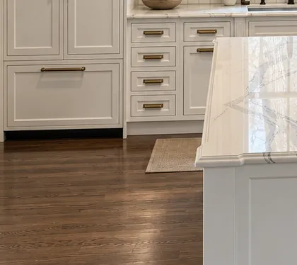 Paneled drawer fronts in a white kitchen beside the island