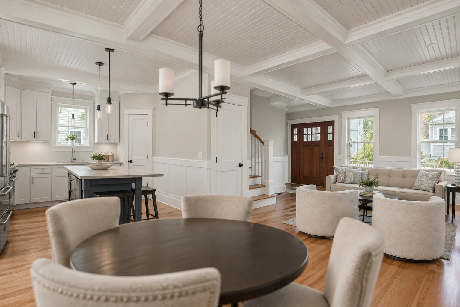 Open room with a coffered ceiling, fitted wall panels and the staircase visible beyond